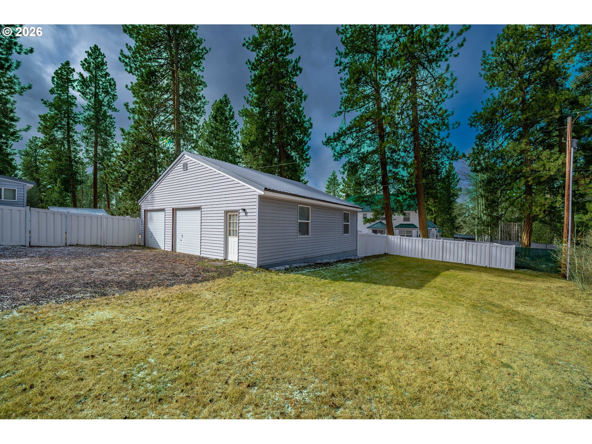 138722 Rhododendron Street Gilchrist, OR 97737 - Photo 26 of 27 a view of a backyard with a cabin and wooden fence