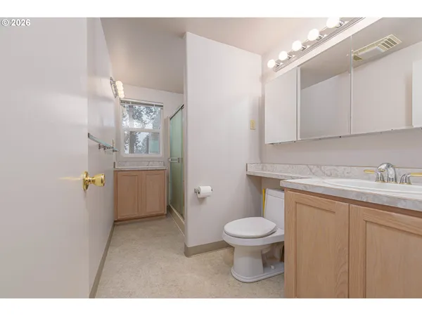 a bathroom with a granite countertop toilet a sink and a mirror