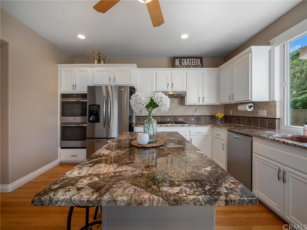 2 Whippoorwill Road Trabuco Canyon, CA 92679 - Photo 22 of 57 a kitchen with stainless steel appliances granite countertop a sink refrigerator and cabinets