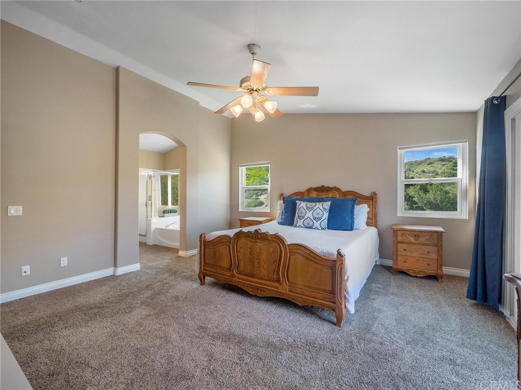 2 Whippoorwill Road Trabuco Canyon, CA 92679 - Photo 28 of 57 a bedroom with a bed and a chandelier