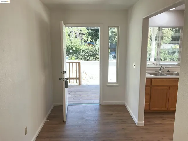 a view of hallway with wooden floor and cabinet