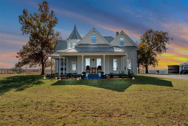 a front view of a house with garden and trees