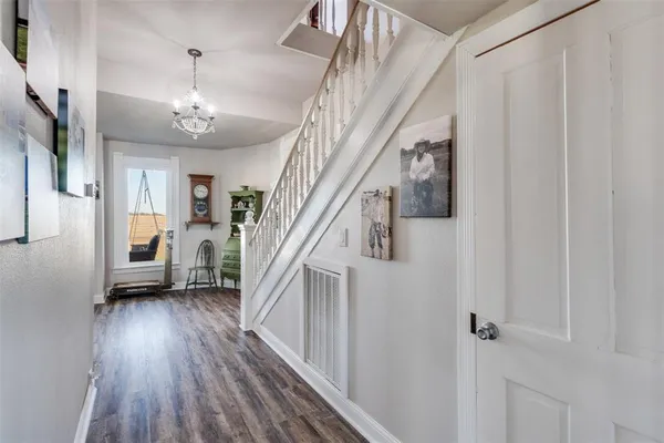 a view of a hallway with wooden floor and staircase