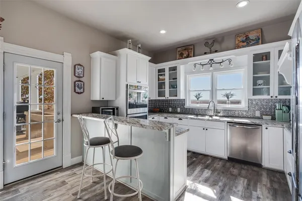 a kitchen with stainless steel appliances granite countertop a stove a sink and a refrigerator