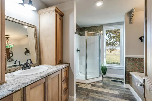 a bathroom with a granite countertop sink mirror and shower