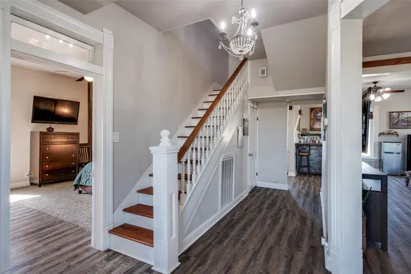 a view of a hallway with wooden floor and staircase