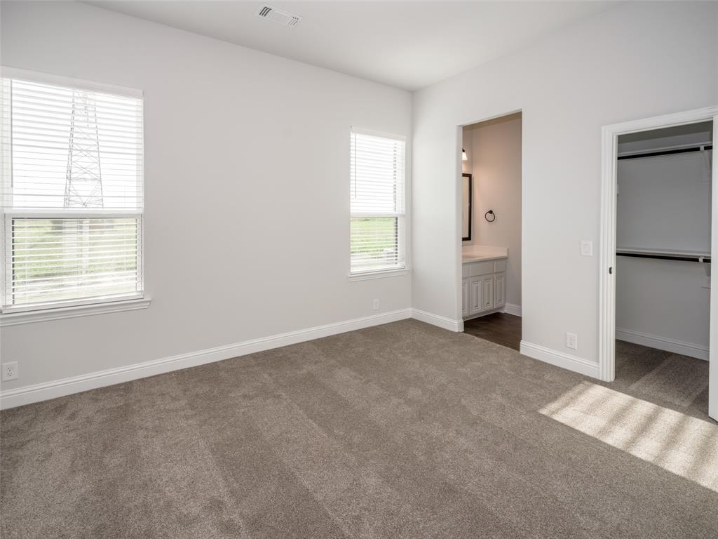 2108 Charters Circle Nevada, TX 75173 - Photo 26 of 37 Unfurnished bedroom featuring dark carpet, a spacious closet, and ensuite bathroom