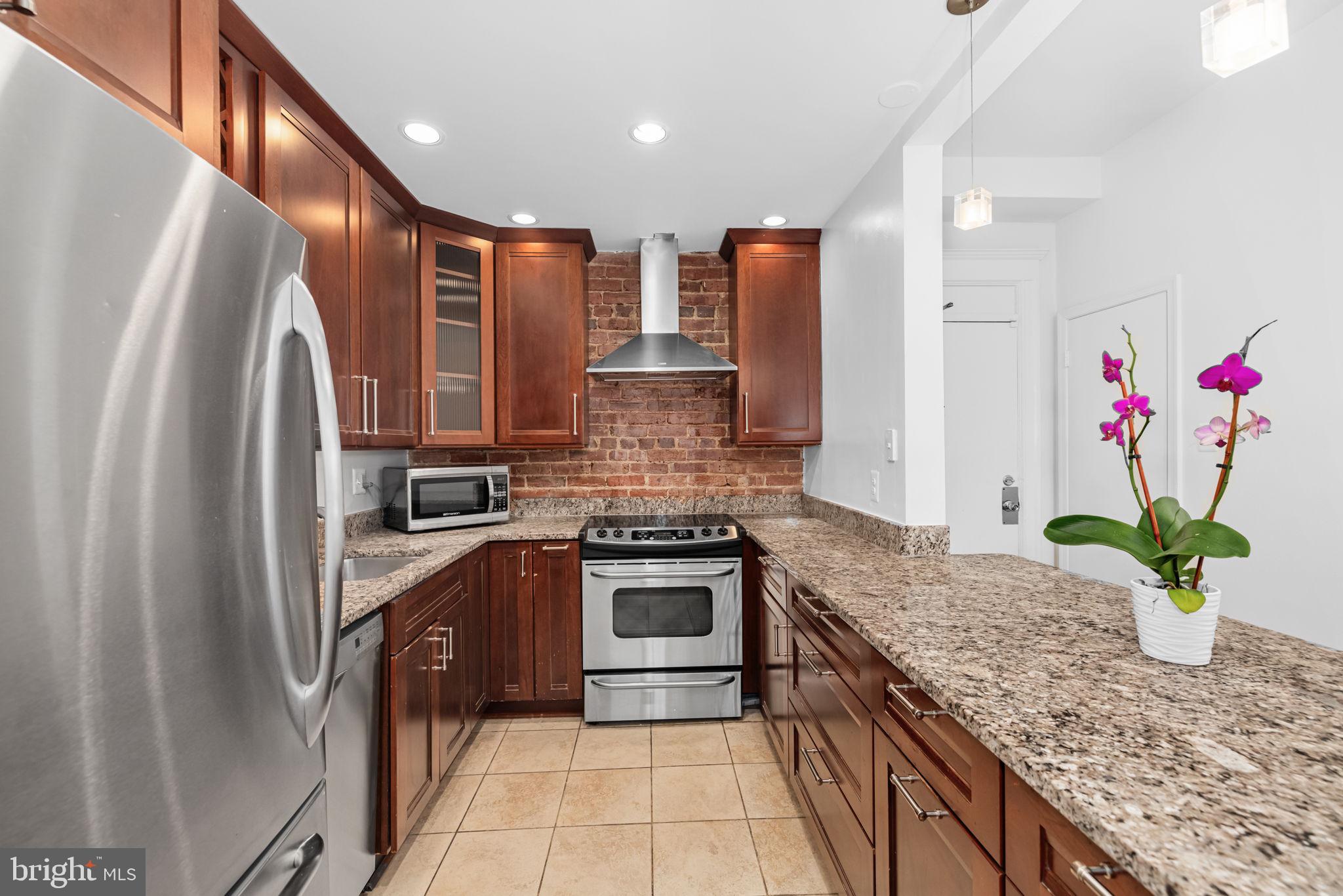 1855 Calvert Street Northwest, Unit 102 Washington, DC 20009 - Photo 9 of 16 Kitchen with exposed Brick