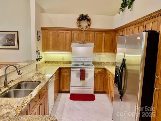a kitchen with stainless steel appliances granite countertop a refrigerator and a sink