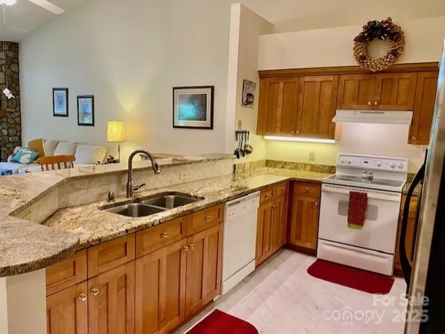 a kitchen with stainless steel appliances granite countertop a sink stove and cabinets