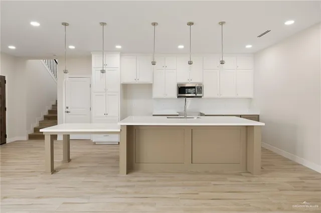 a view of kitchen with stainless steel appliances kitchen island sink stove and living room view