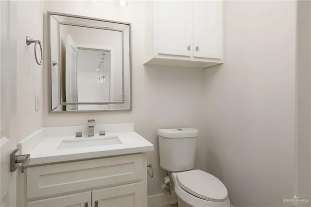 a bathroom with a toilet sink vanity and mirror