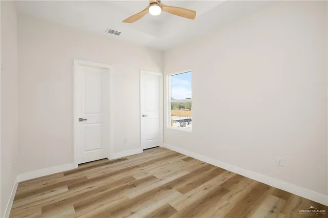 an empty room with a window and ceiling fan