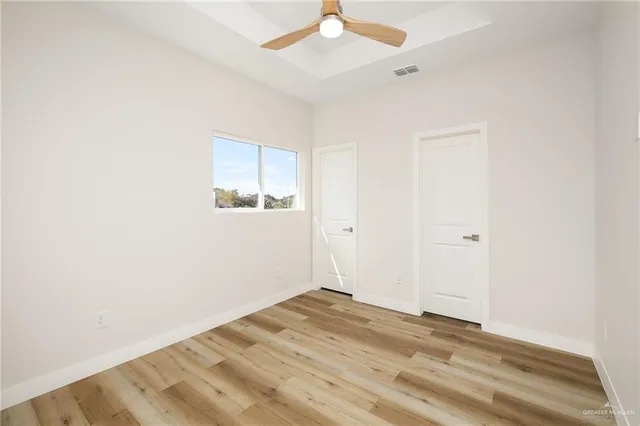 an empty room with a ceiling fan and a window