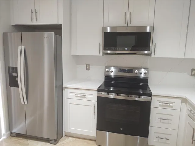 a kitchen with stainless steel appliances a stove a microwave and cabinets