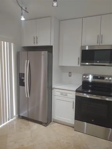a kitchen with a refrigerator stove and microwave
