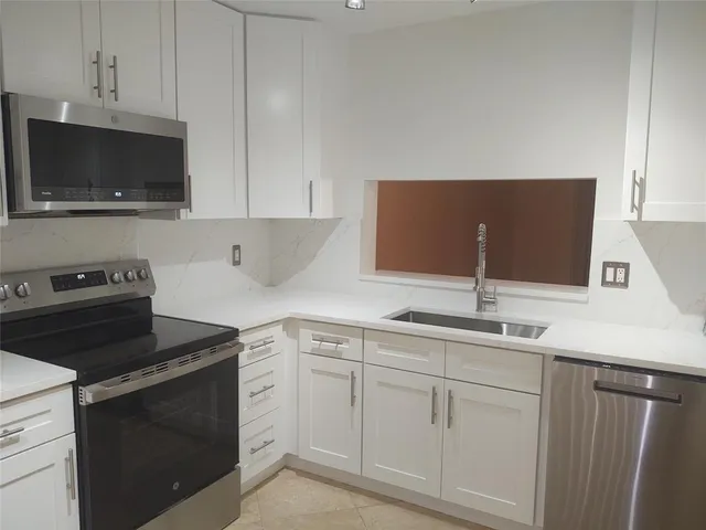 a kitchen with appliances cabinets and a sink