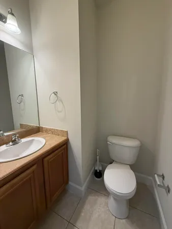 a bathroom with a granite countertop toilet and a sink