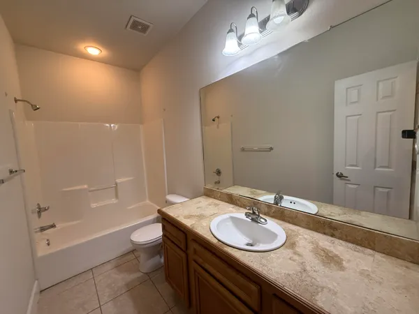 a bathroom with a granite countertop sink a toilet and a mirror