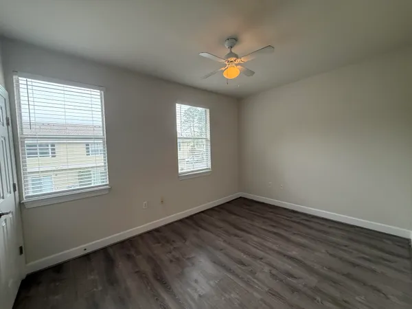 an empty room with wooden floor and white walls