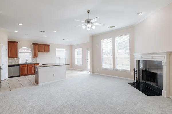 a large white kitchen with a large window and stainless steel appliances