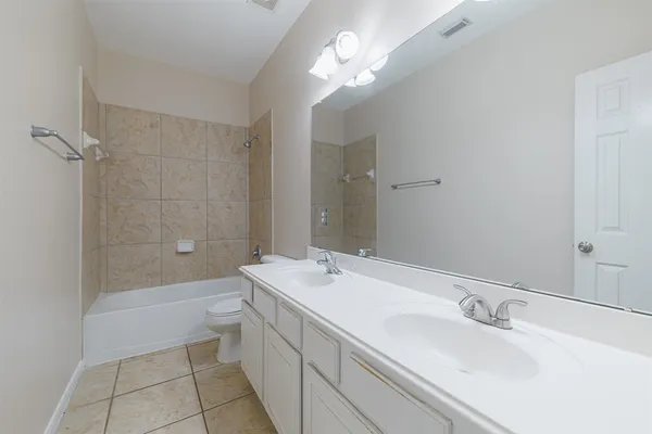 a bathroom with a sink a toilet a mirror and shower