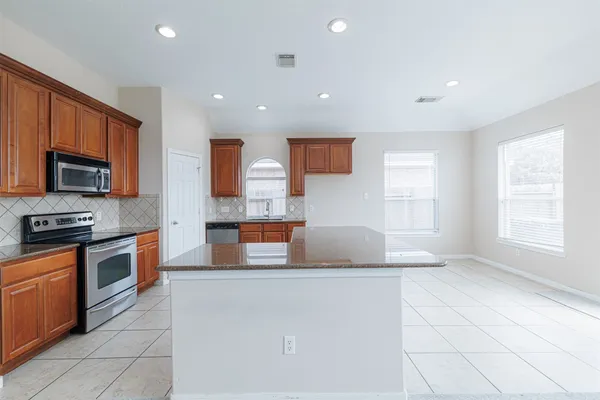 a kitchen with stainless steel appliances granite countertop a sink and a stove