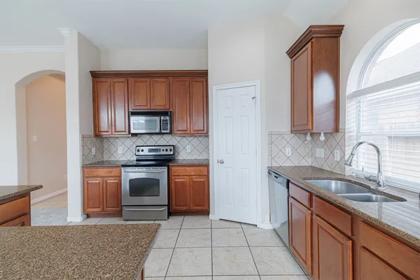 a kitchen with stainless steel appliances granite countertop a sink and a stove