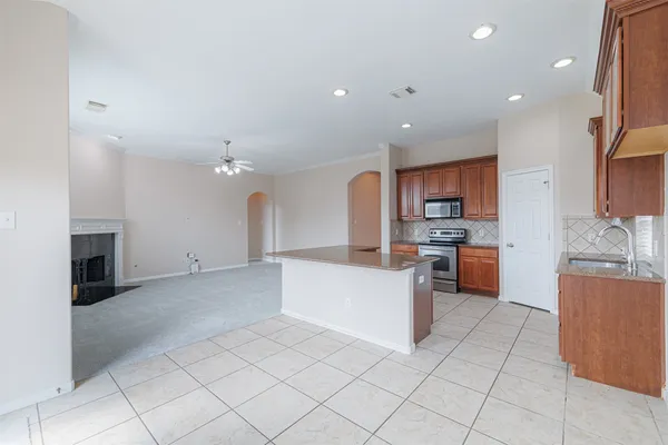 a large kitchen with stainless steel appliances kitchen island granite countertop a sink and cabinets