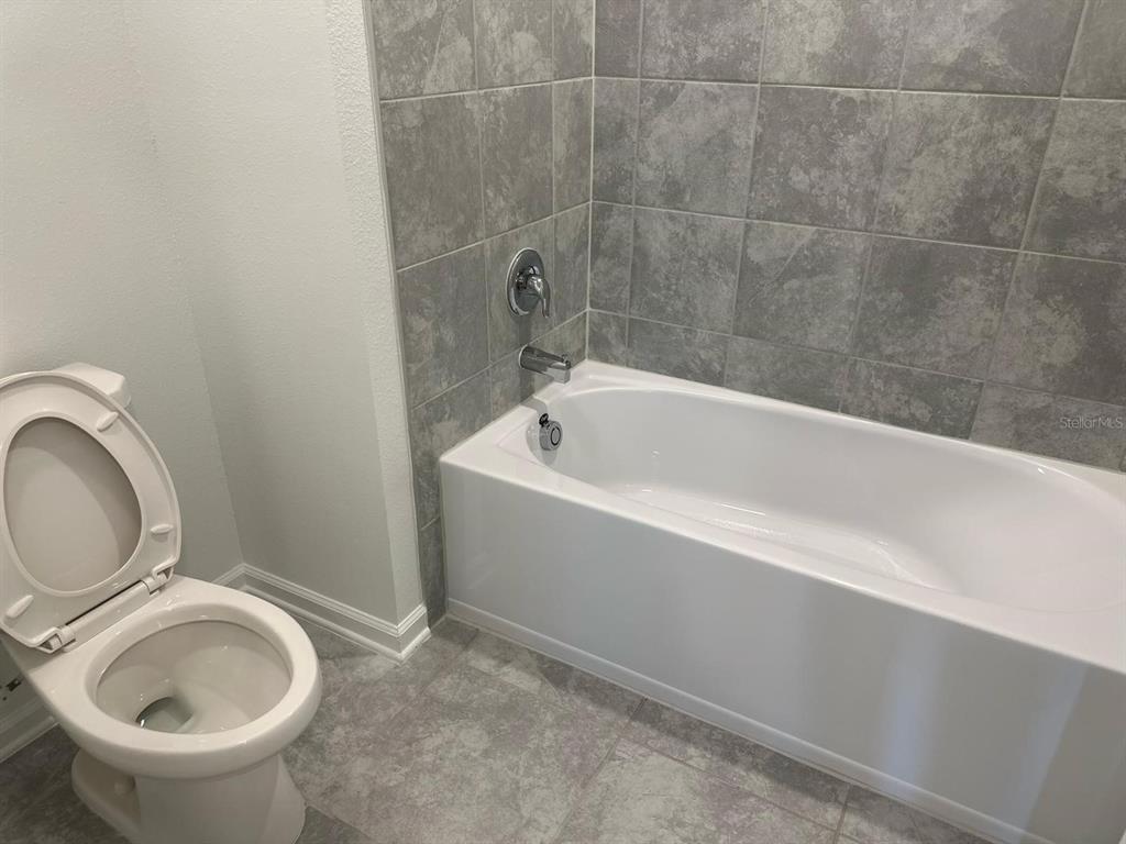 417 Cedar Key Street Davenport, FL 33837 - Photo 21 of 58 a white bath tub sitting next to a toilet