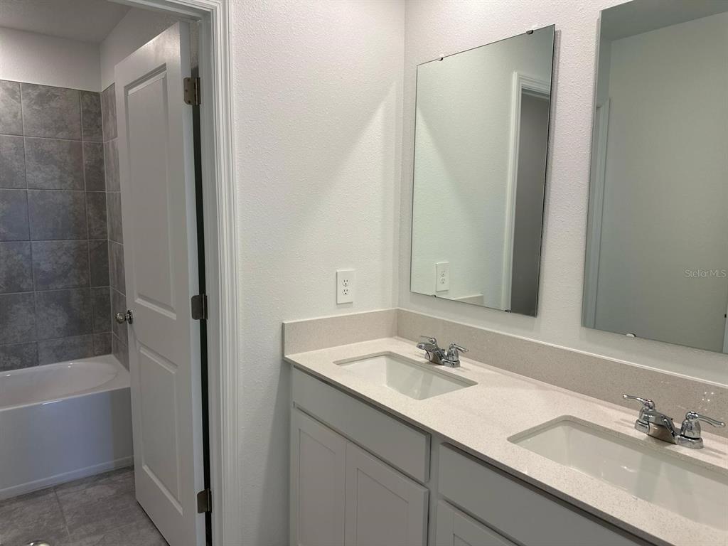 417 Cedar Key Street Davenport, FL 33837 - Photo 22 of 58 a bathroom with a sink and a mirror