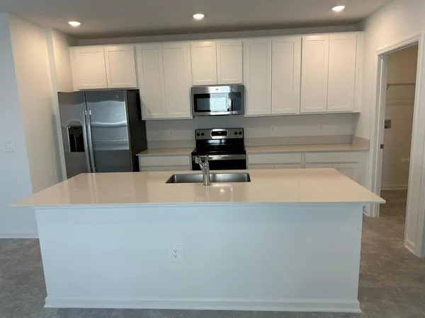 a kitchen with stainless steel appliances a refrigerator a stove a microwave and sink