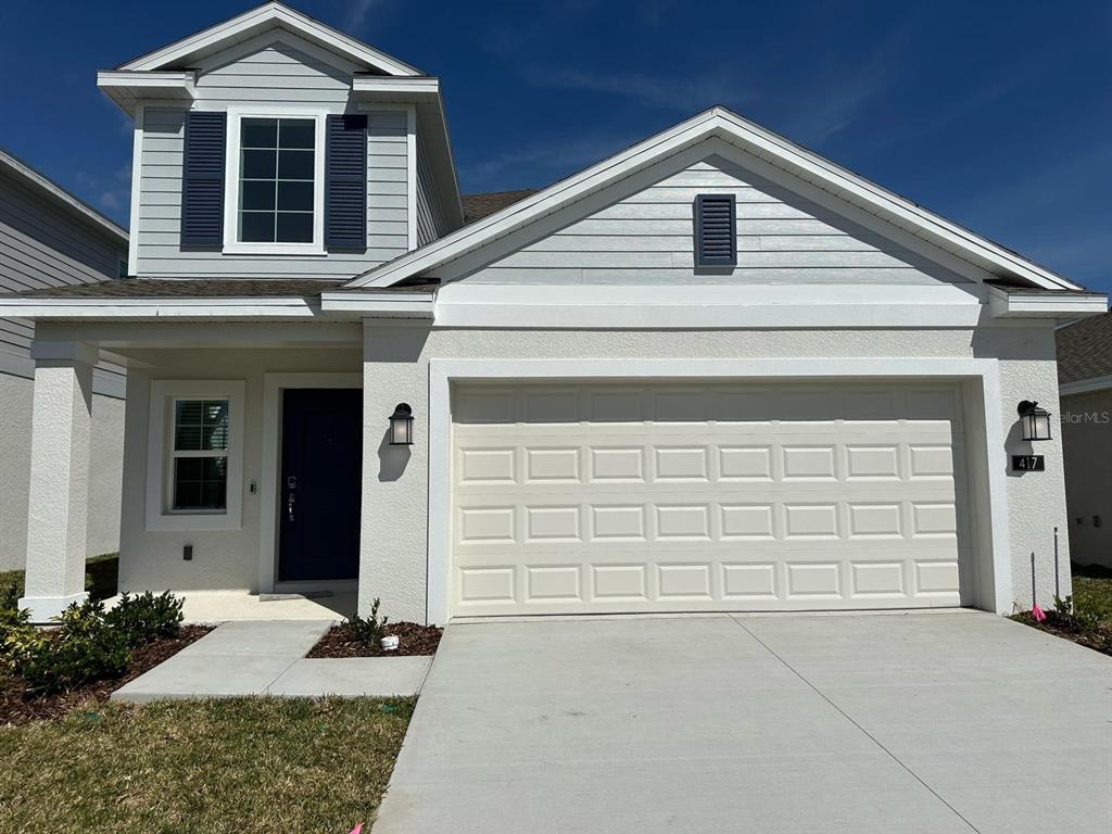 417 Cedar Key Street Davenport, FL 33837 - Photo 31 of 58 a front view of a house with a yard and garage