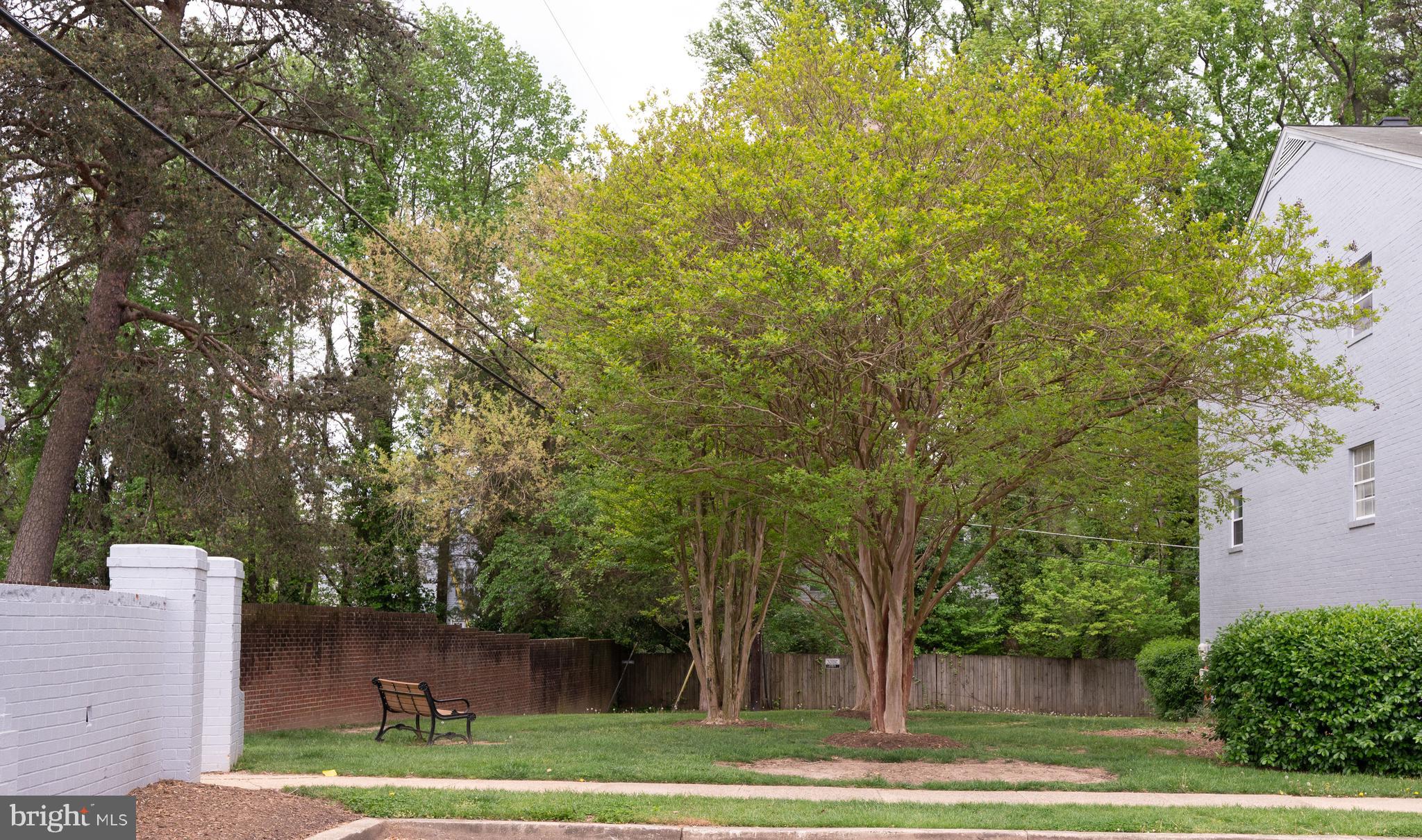 7097 Spring Garden Drive, Unit 101 Springfield, VA 22150 - Photo 16 of 17 a view of a patio with green space and wooden fence