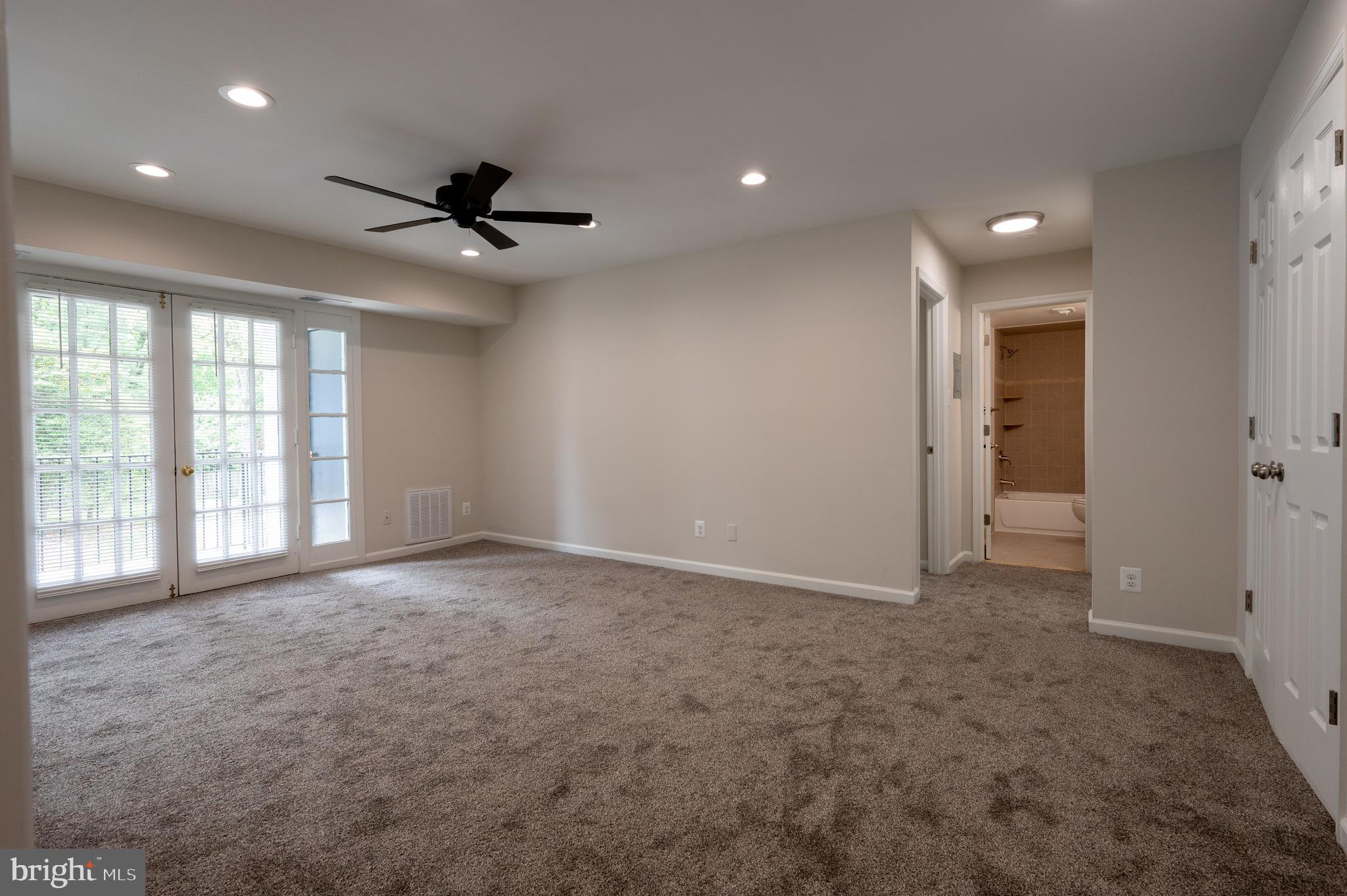 7097 Spring Garden Drive, Unit 101 Springfield, VA 22150 - Photo 4 of 17 an empty room with windows and a ceiling fan