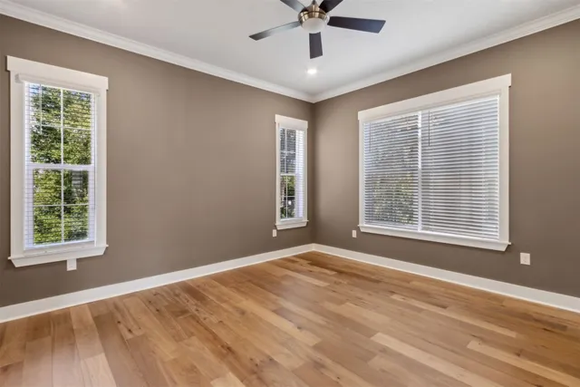 a view of sign board with flower plants and wooden fence