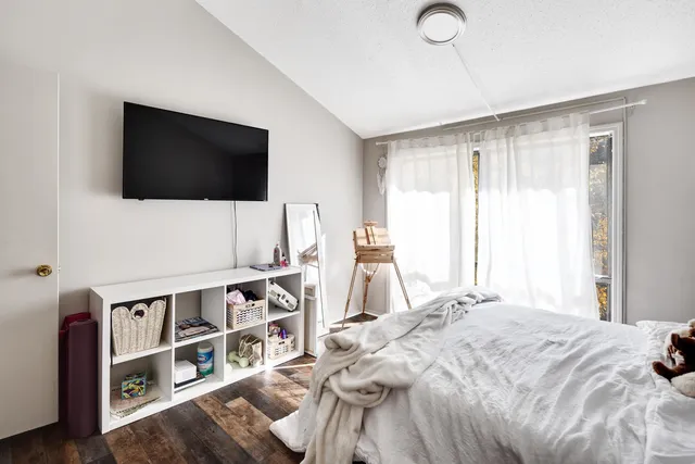 a bedroom with a bed and a flat screen tv