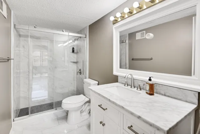 a bathroom with a sink a toilet and shower