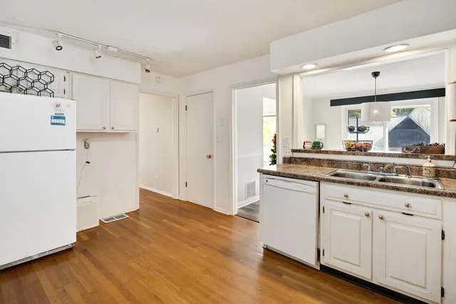 a kitchen with granite countertop white cabinets and white appliances