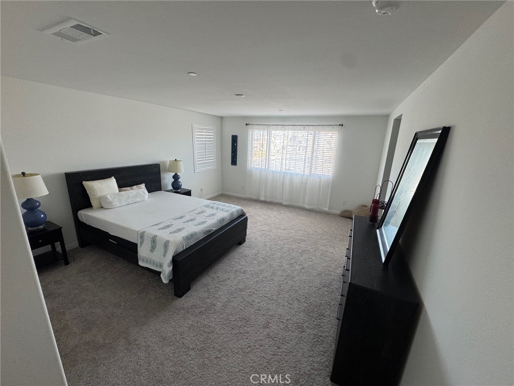 4515 Bandon Avenue Perris, CA 92571 - Photo 21 of 26 a bedroom with a bed and wooden floor