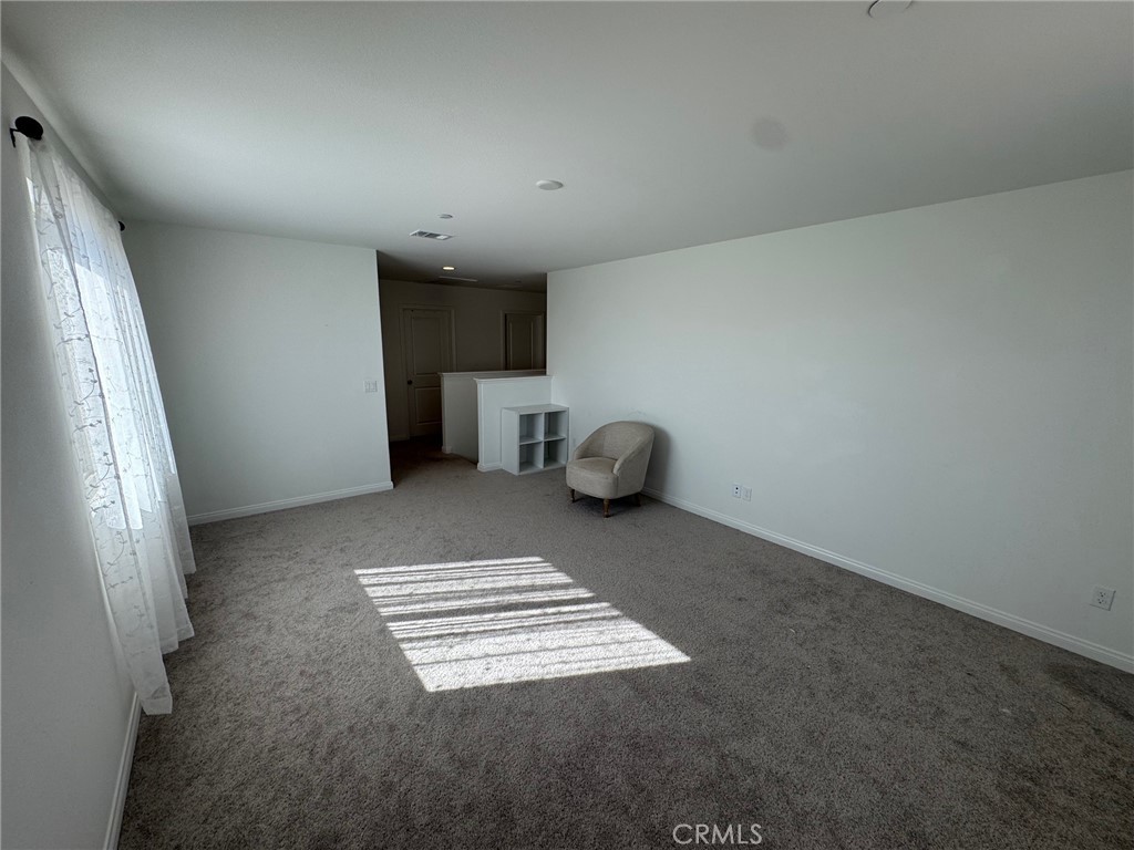 4515 Bandon Avenue Perris, CA 92571 - Photo 26 of 26 an empty room with a fireplace and window