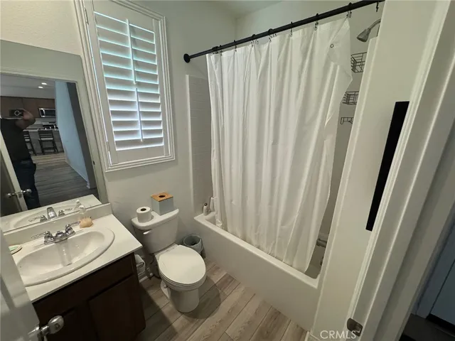 a bathroom with a sink a toilet and shower curtain