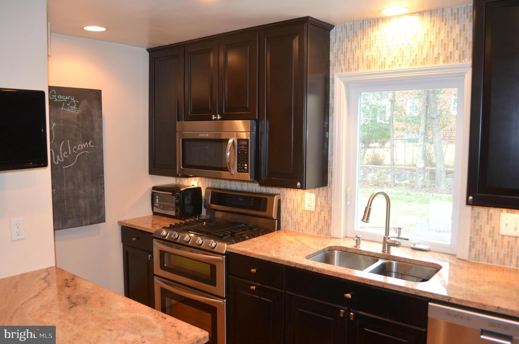106 Indian Spring Drive Silver Spring, MD 20901 - Photo 17 of 30 a kitchen with granite countertop a sink and a stove top oven
