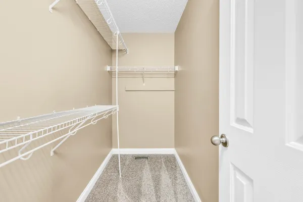 a view of walk in closet with empty racks