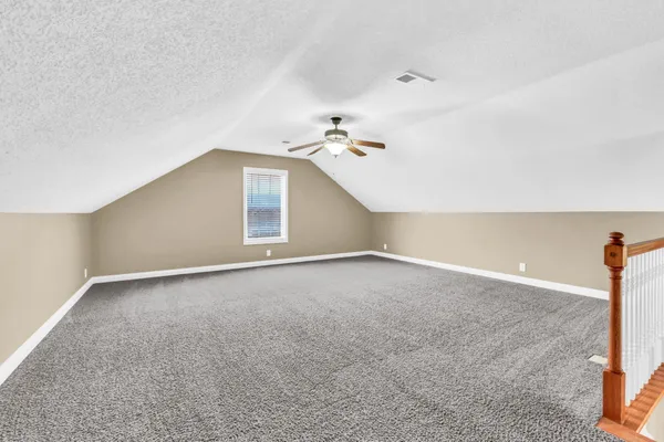 a view of a room with a ceiling fan and window