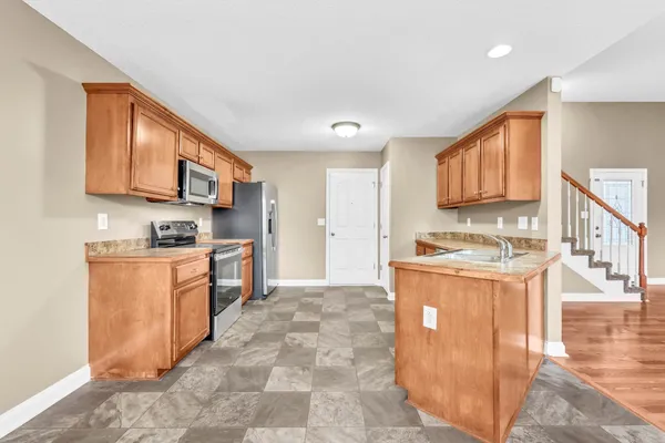 a kitchen with stainless steel appliances granite countertop a stove a sink dishwasher and a refrigerator
