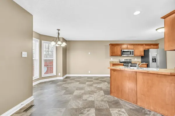 a view of a kitchen with kitchen island a sink stainless steel appliances and cabinets