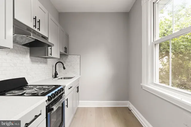 a kitchen with a sink a stove and a window