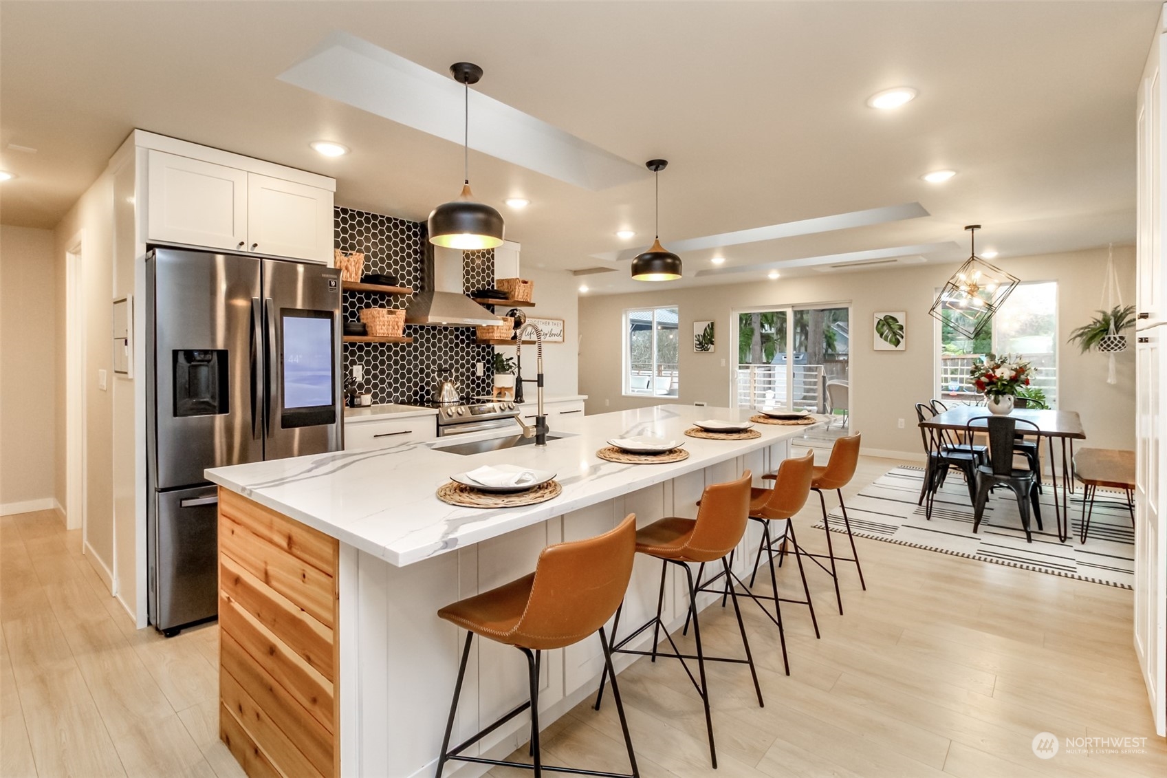 3017 Forest Rim Court South Puyallup, WA 98374 - Photo 6 of 40 a kitchen with stainless steel appliances kitchen island granite countertop a table chairs and a refrigerator