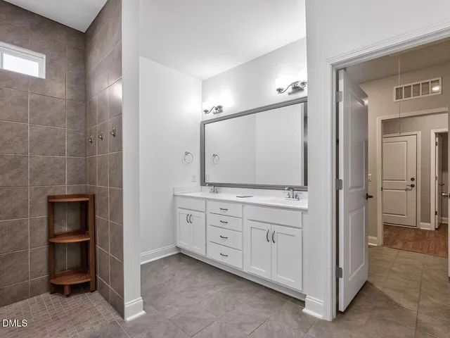 a bathroom with a double vanity sink and mirror